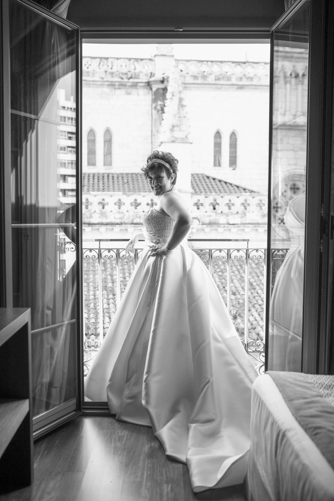 Novia posando con vestido pomposo en balcón durante boda en Madrid